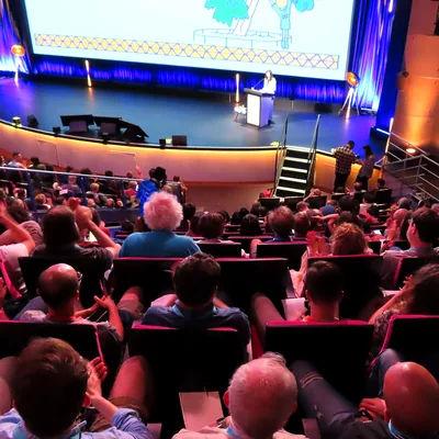 Público atento en un auditorio durante una charla de formación